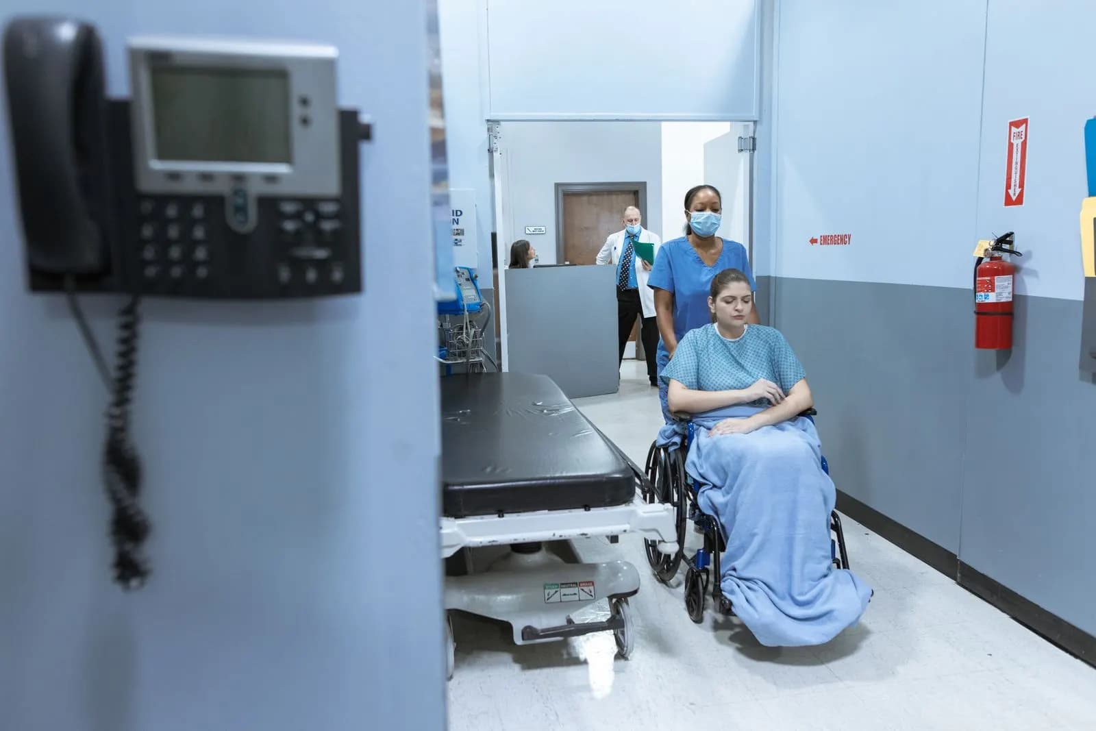 Enfermeira auxiliando paciente em corredor de hospital — prazos de atendimento do plano de saúde